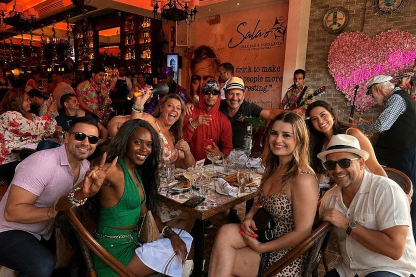 Un gruppo di persone sedute a un tavolo in un ristorante con una decorazione a forma di cuore sulla parete. 3