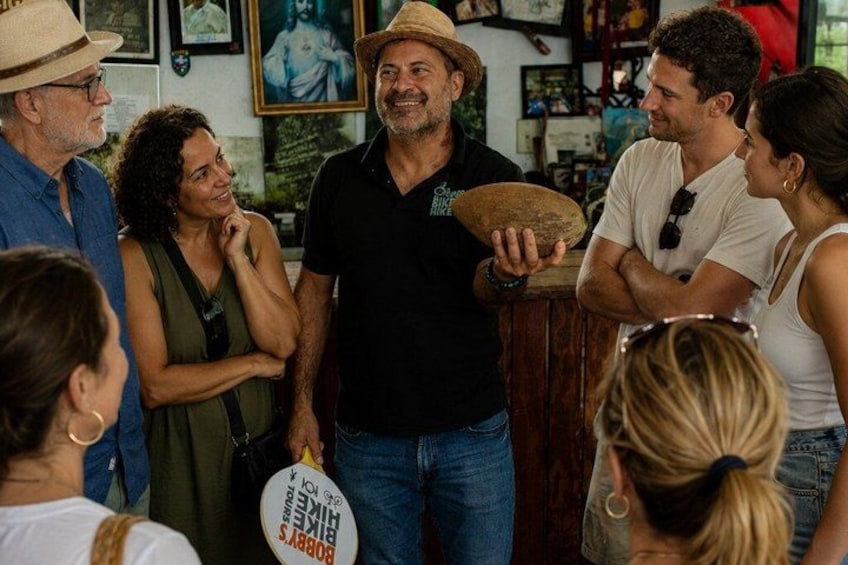 Un gruppo di persone in un ambiente interno informale, forse un caffè o un bar, con una persona che tiene in mano un oggetto rotondo. 2