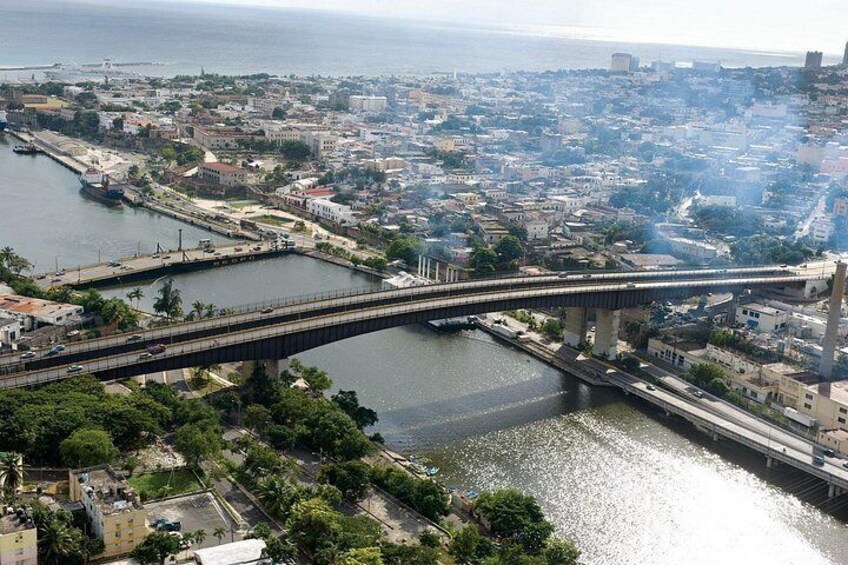 Un puente que cruza un río, rodeado de edificios urbanos y vegetación. 3