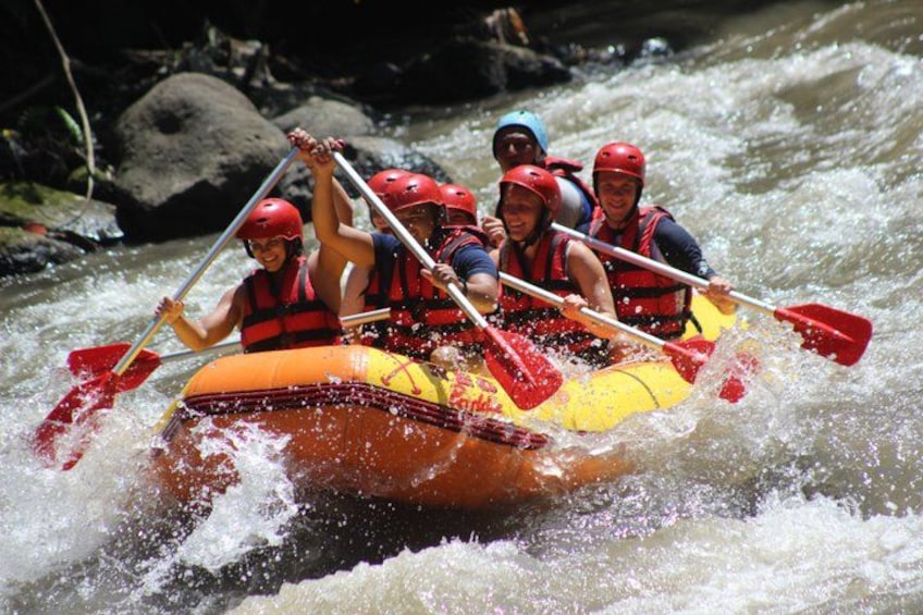 Een groep mensen in een gele vlot die een rivier met tochtige stukken afvaart. 5