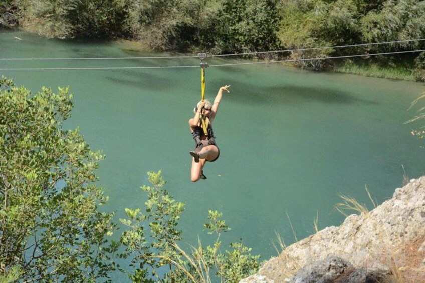 Een persoon springt bungeejumpend van een klif boven het water. 3