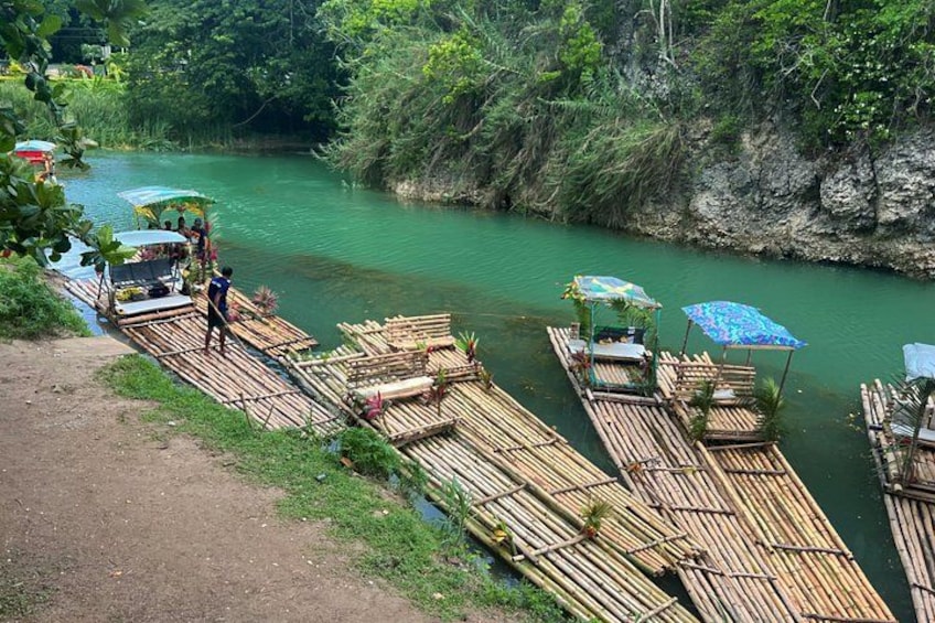 Bamboo rafts on a river, surrounded by greenery. 2