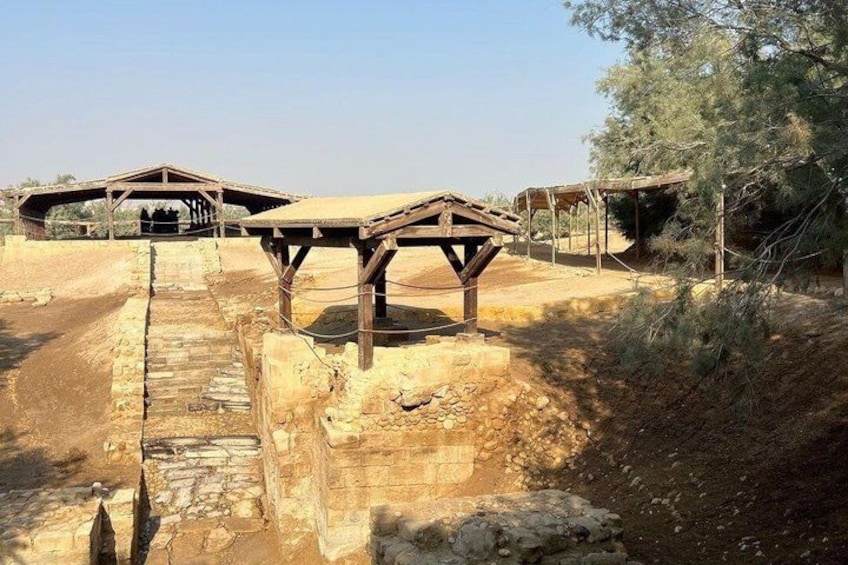 Un site archéologique comprenant des structures en bois et un sentier pavé de pierres. 2