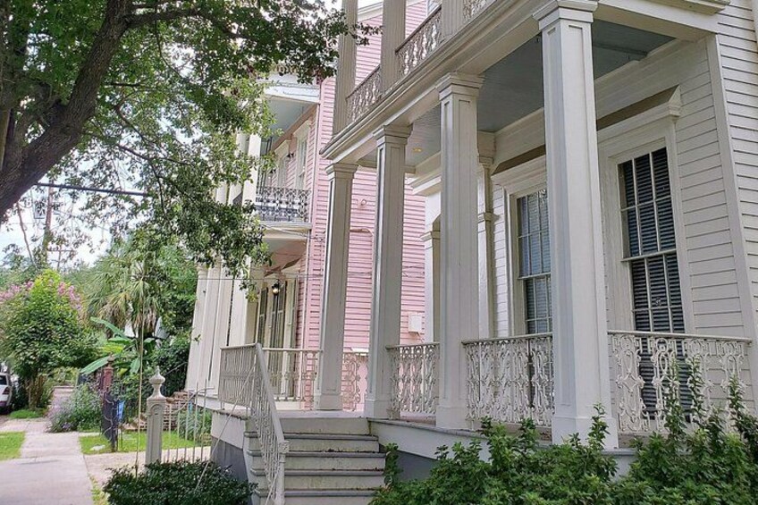 A two-story house with a porch, columns, and a staircase. 2