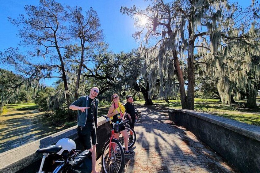 A paved pathway, a bicycle, and trees with hanging moss. 1