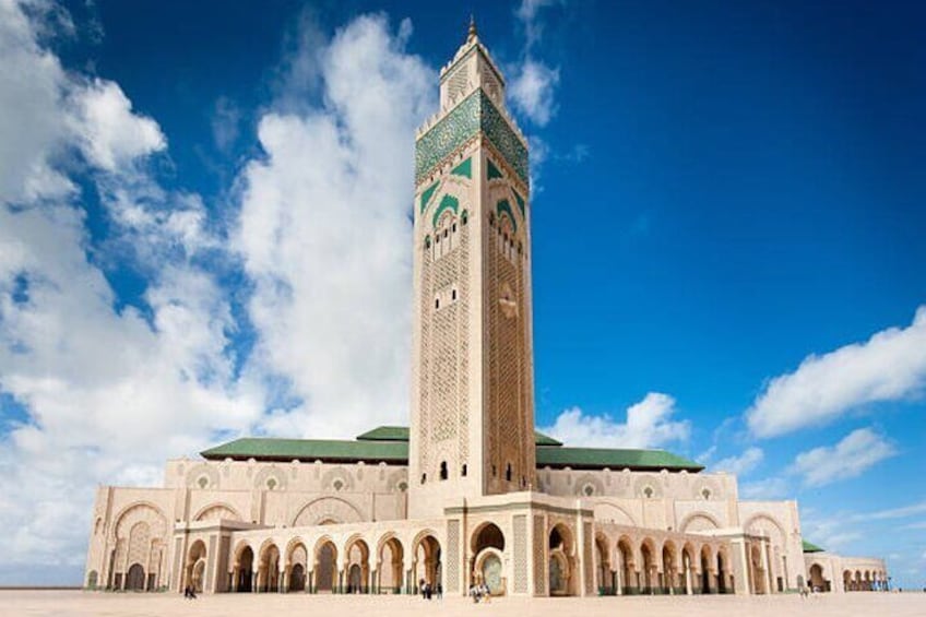 A large mosque with a tall minaret and multiple arches. 1