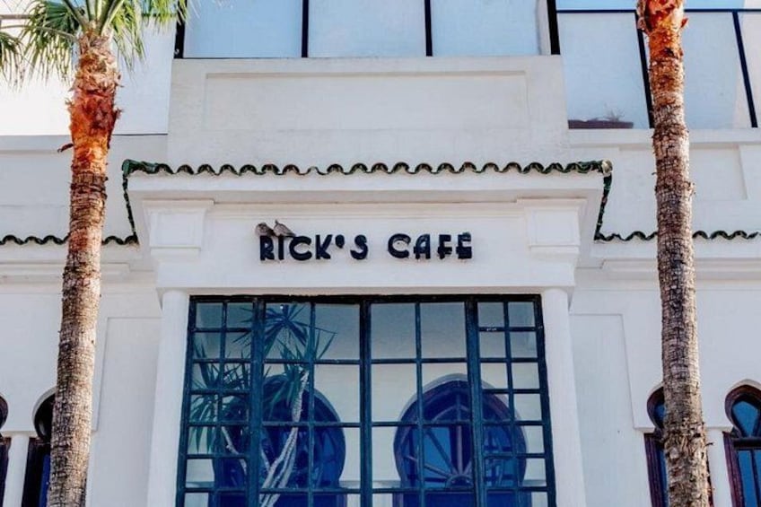 A building with a sign that reads 'Rick's Cafe.' 2