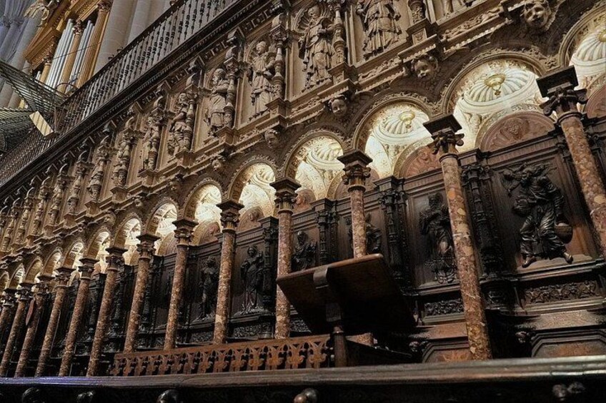 An ornate interior with detailed carvings, columns, and a balcony. 3