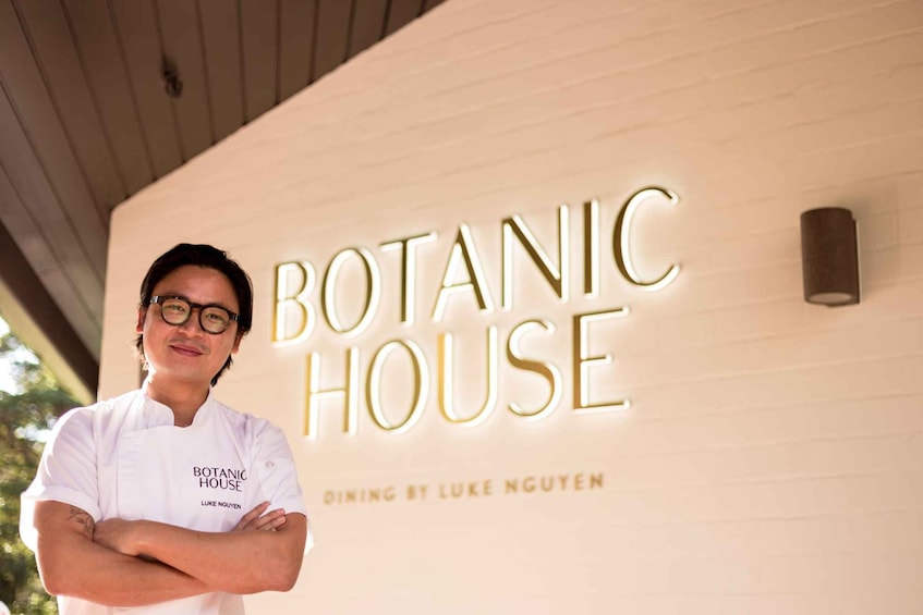 Henkilö seisoo rakennuksen edessä, ja rakennuksen kyltissä lukee: ”BOTANIC HOUSE”. 4
