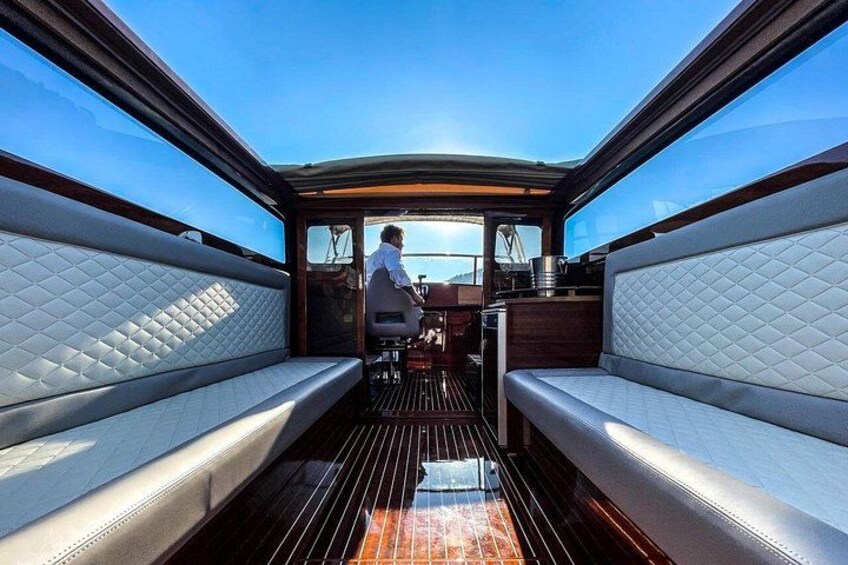 A boat's interior with cushioned seating and a wooden deck. 5