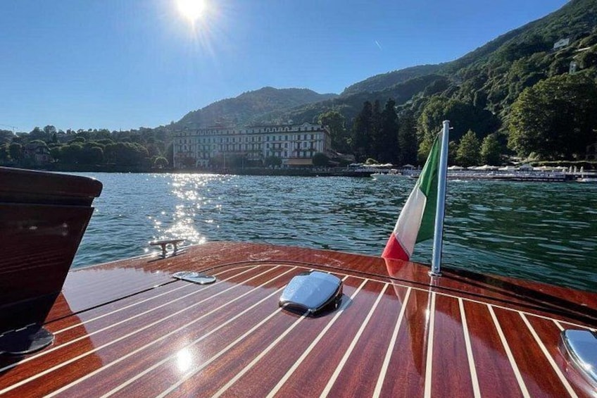 A wooden boat deck with a flag, a smartphone, and a pair of sunglasses. 2