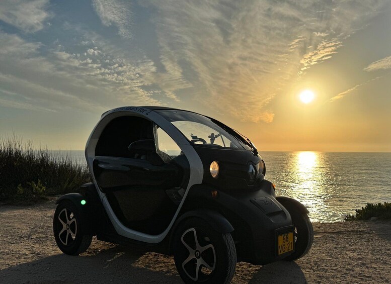 Un'auto compatta parcheggiata sulla spiaggia al tramonto. 2