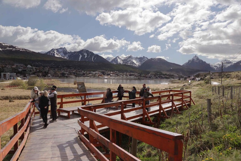 Un puente de madera sobre un río, con un paisaje montañoso al fondo. 2
