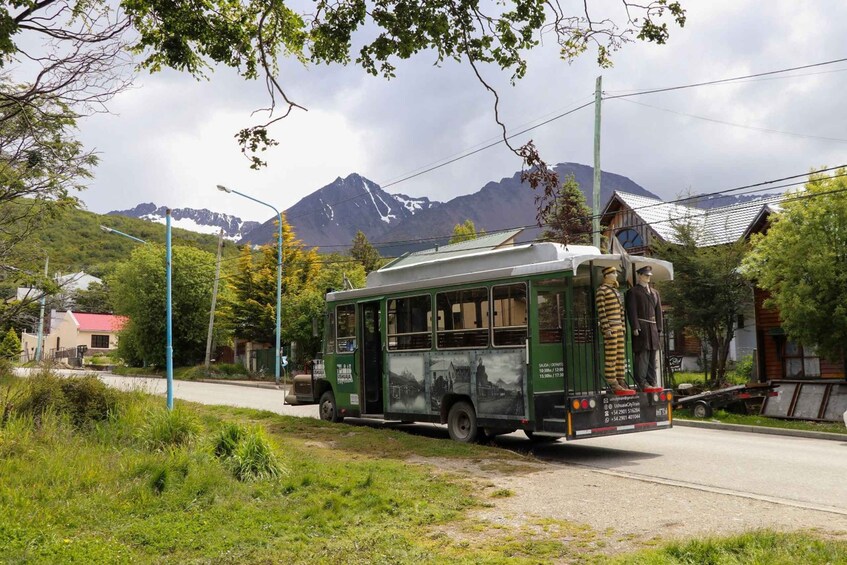 Un autobús verde estacionado en una carretera con montañas al fondo. 3