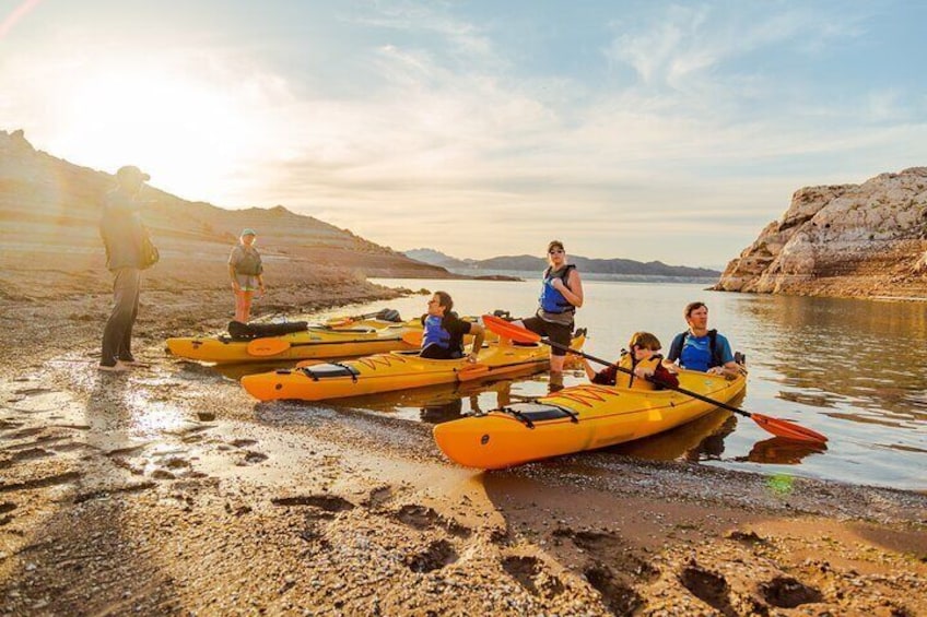 People in kayaks on a riverbank. 1