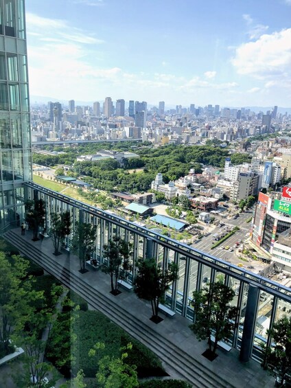 A cityscape with a modern building, a green park, and a busy street. 4
