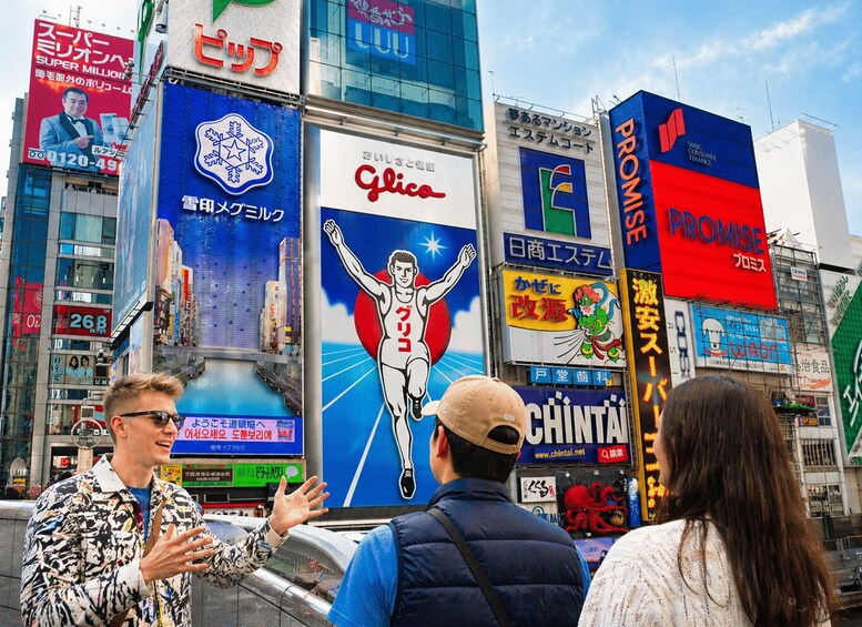 A busy urban street with large billboards and advertisements. 1