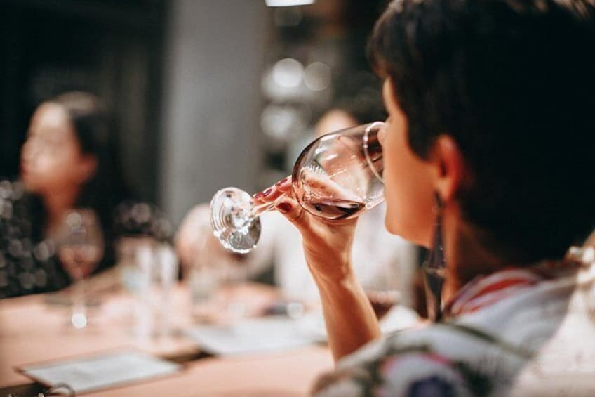 A person holding a wine glass, presumably drinking. 4