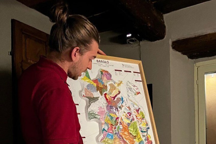 A person examining a colorful map with various regions marked. 2