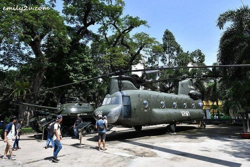 A military helicopter parked outdoors with people standing around it. 2