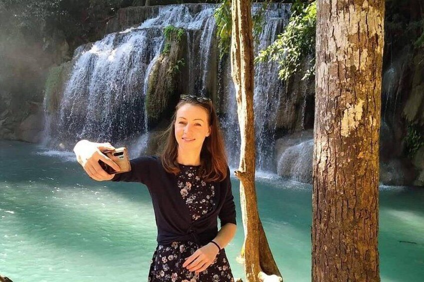 A person taking a selfie with a waterfall in the background. 2
