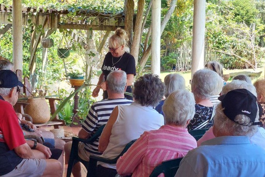 A group of people seated outdoors, listening to a speaker. 3