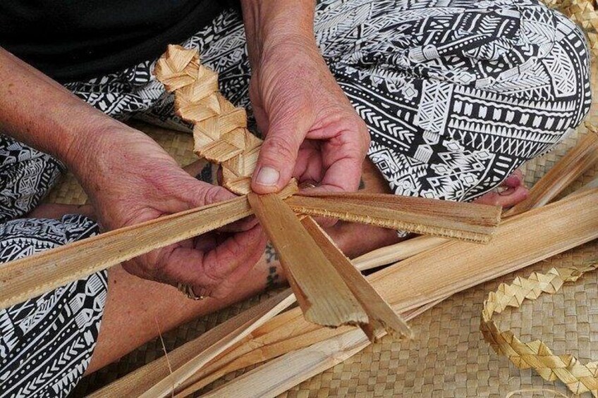 Hands weaving a basket with a woven pattern. 3
