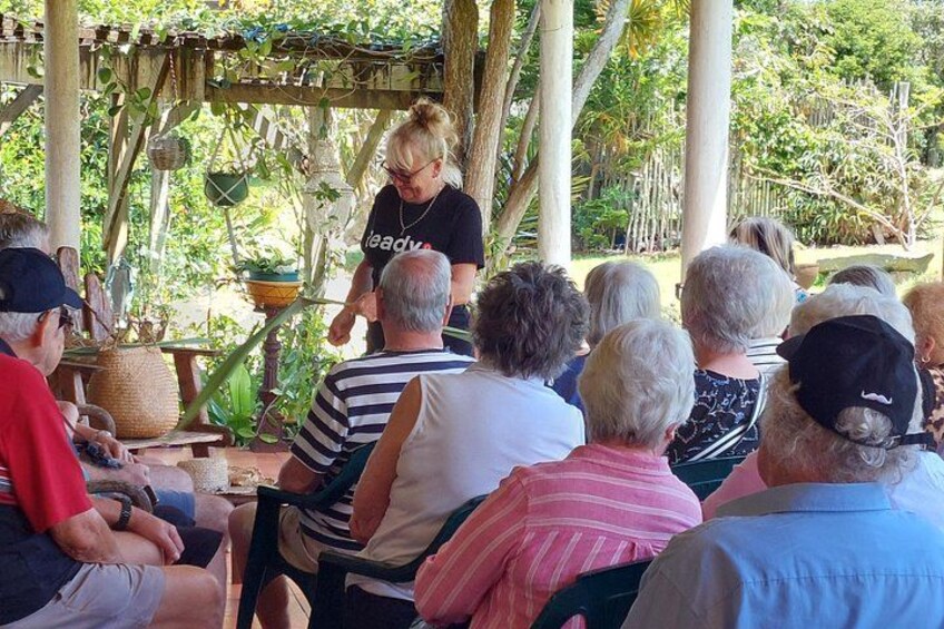 A group of people seated outdoors, listening to a speaker. 3
