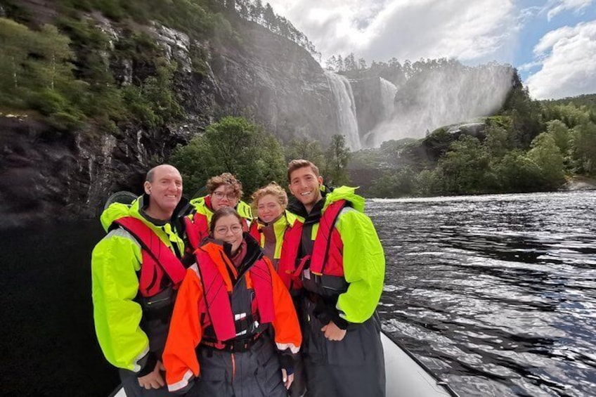 En grupp människor i en båt nära ett vattenfall. 4