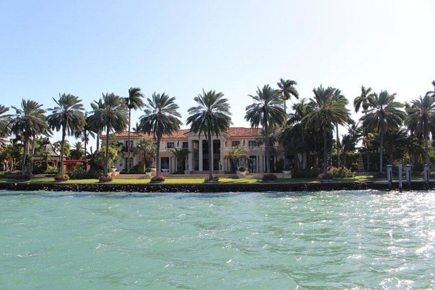 A waterfront property with palm trees and a large building. 2
