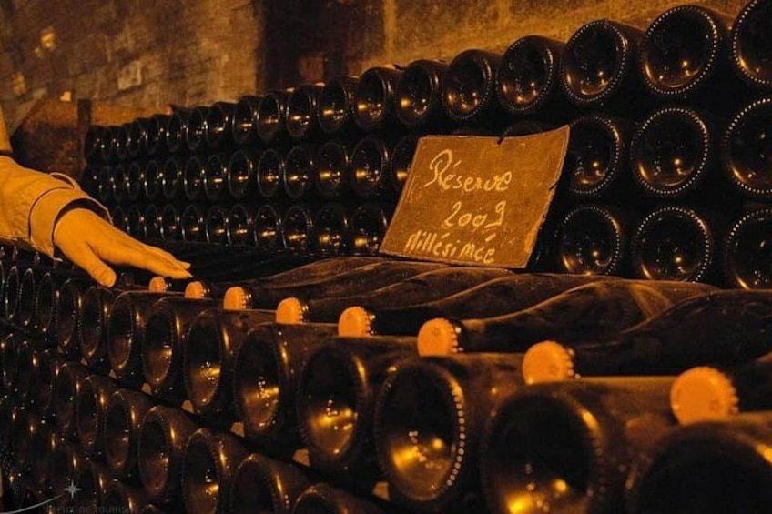 Numerose bottiglie di vino disposte in file, con un cartello che indica un vino riserva. 5