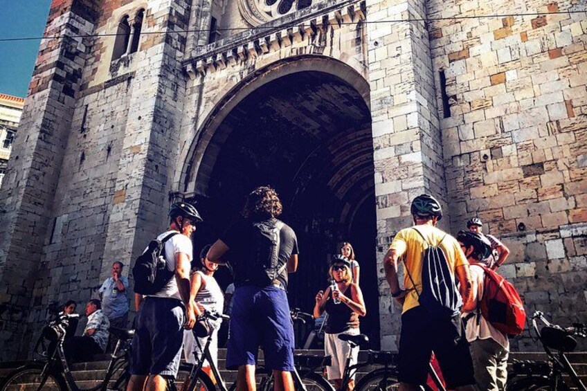 Ein historischer Steinbogen mit Touristen und Radfahrern. 3