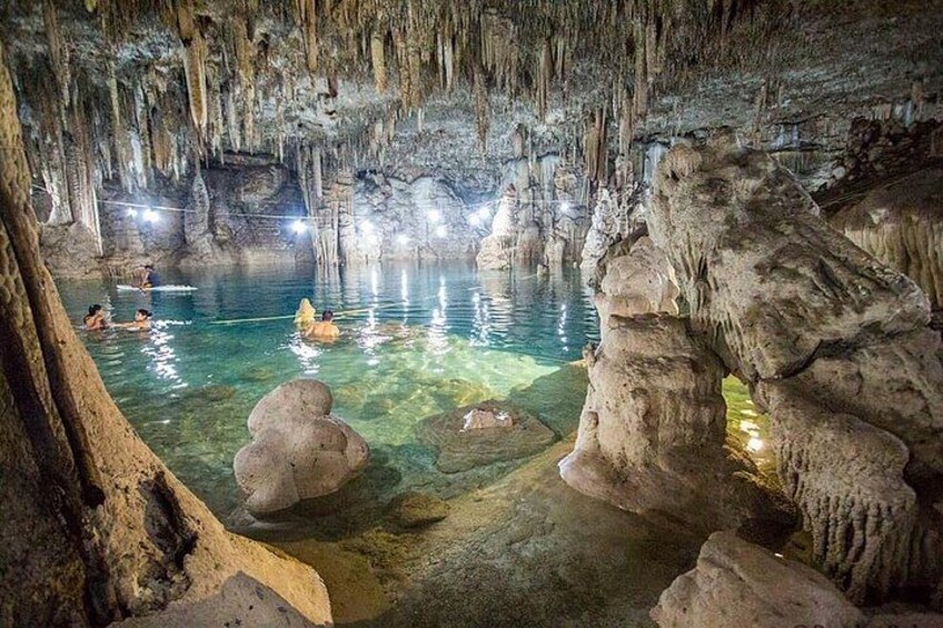 En hule med stalaktitter og stalagmitter, klart vand og folk, der svømmer. 2