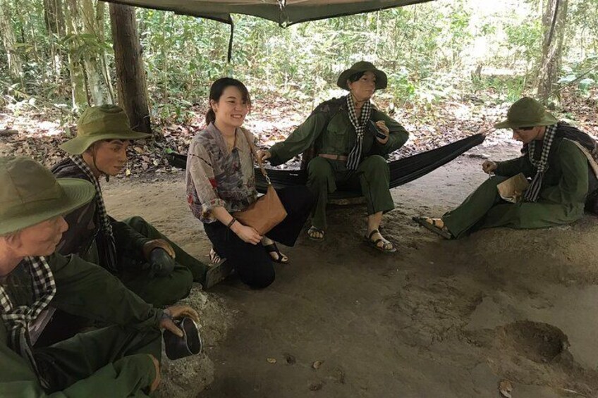 Un groupe de personnes est assis en cercle à l’extérieur, certaines portant des uniformes et des casquettes verts. 3