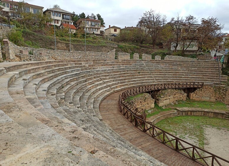 Un anfiteatro antiguo con escalones de piedra y una plataforma de madera para espectadores. 2