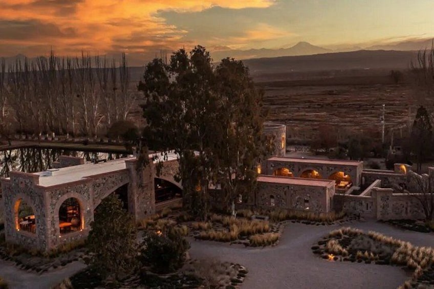 A stone bridge, a building with domed roofs, and a mountainous landscape in the background. 5