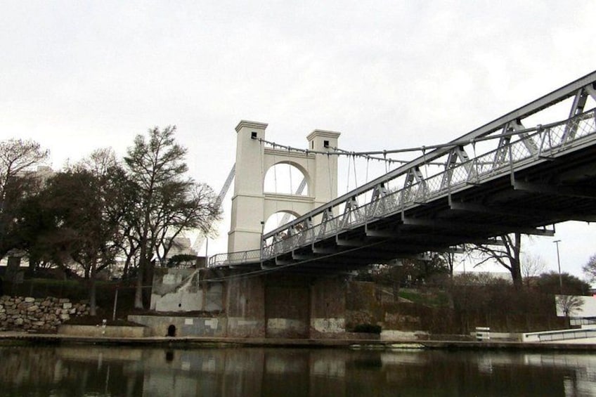 A bridge over a body of water with a large white tower structure in the background. 3