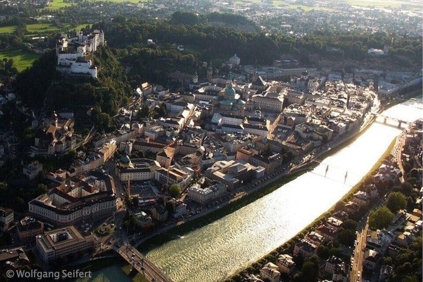 An aerial view of a city with a river, historic buildings, and a castle on a hill. 3