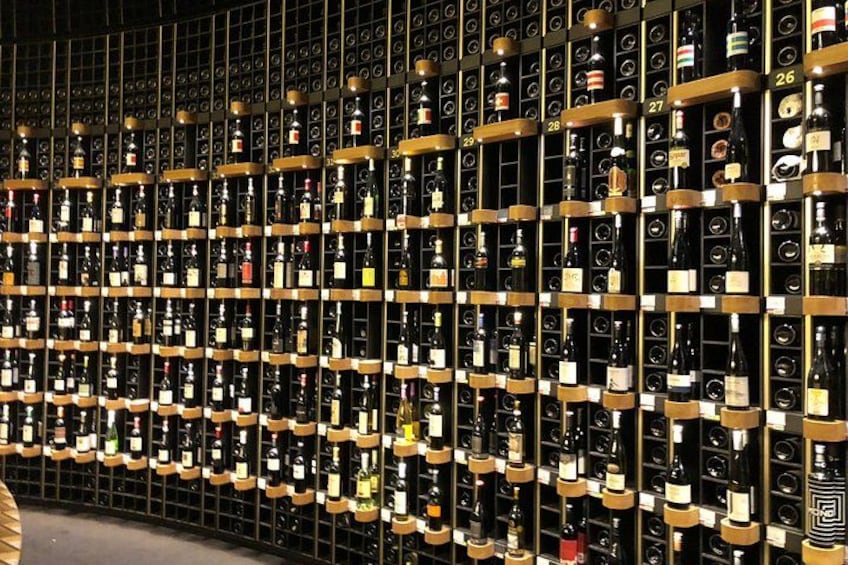 A wine cellar with rows of wine bottles on shelves. 2