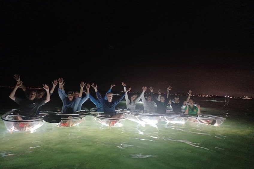 Personas dentro de tubos transparentes en un césped de noche. 2