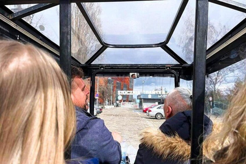 En bussinredning med passagerare som tittar ut på en snötäckt gata med bilar och byggnader. 4