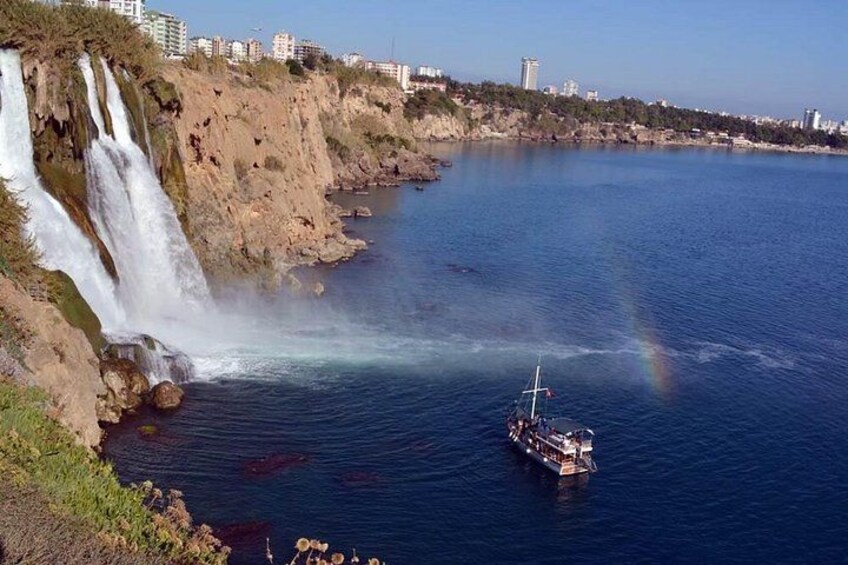 Een waterval, een boot en een stadsgezicht op de achtergrond. 1