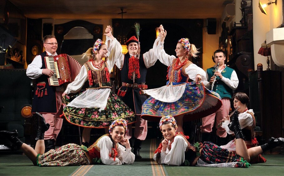 Un grupo de personas con trajes típicos actuando en un escenario. 5