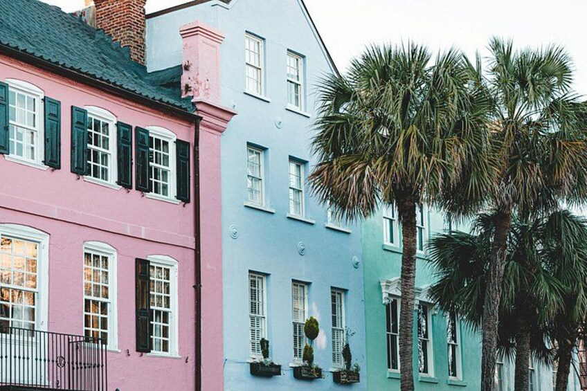 A row of colorful buildings with shutters, a palm tree, and a brick chimney. 2