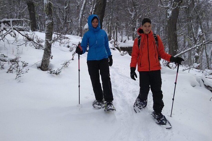 Twee mensen skiën op een besneeuwde bospad. 1