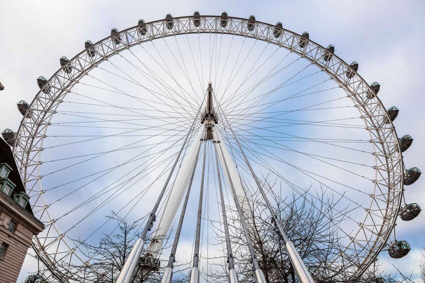 A large Ferris wheel with multiple cabins, set against a partly cloudy sky. 5