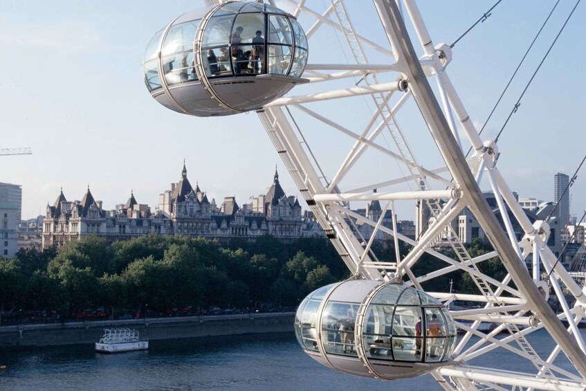 A cable car system with passengers, a river, and a city skyline in the background. 4