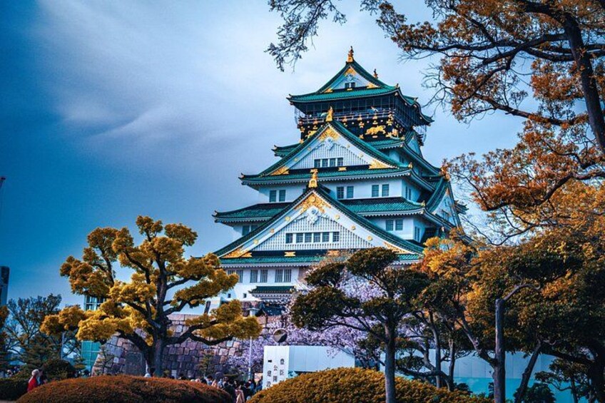 Un castillo japonés tradicional con varios niveles, rodeado de árboles con follaje otoñal. 3