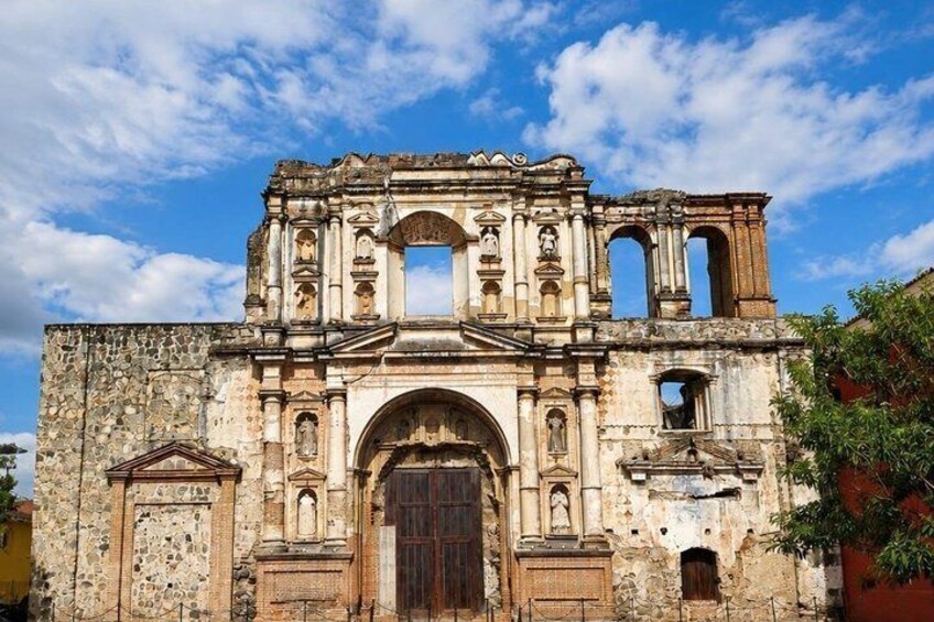 An old stone building with arched doorways and a central archway. 5