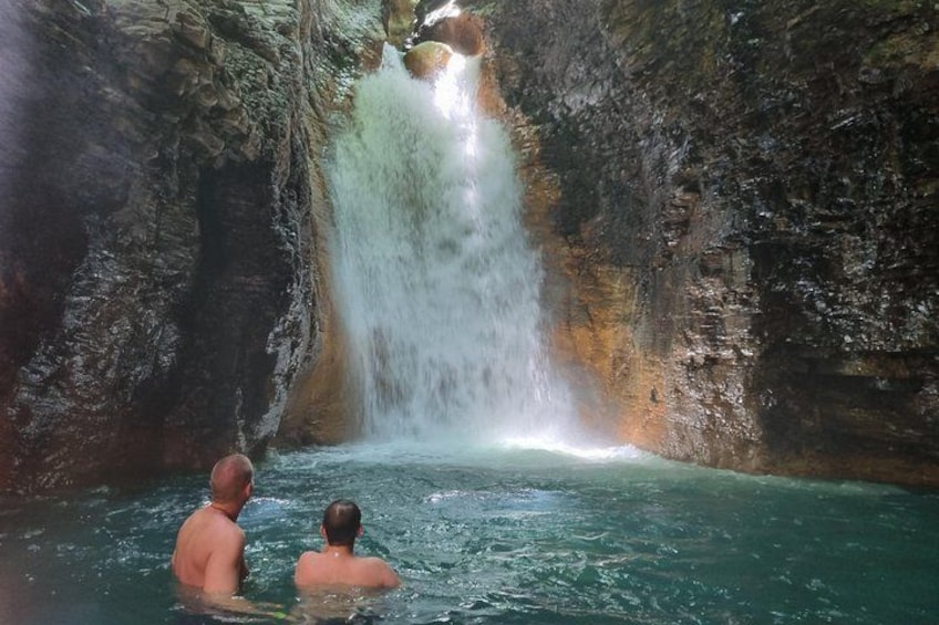 Two people in a natural pool with a waterfall. 2